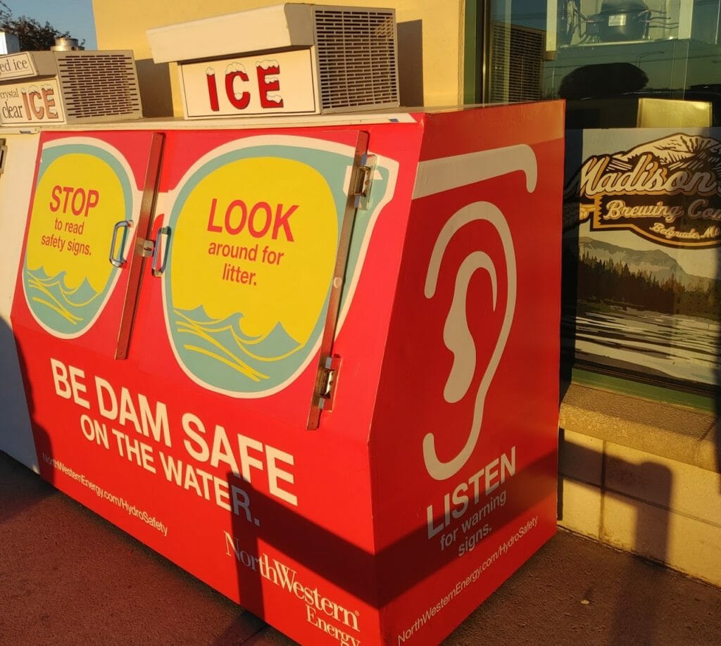 Ice box outside of a convenience store with an advertisement on it