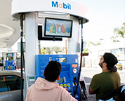 A screen displays advertisements above a gas pump