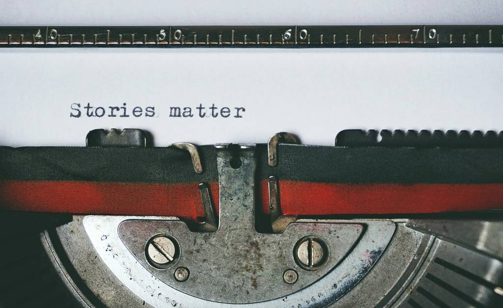 A typewriter with a piece of paper that says "stories matter" on it.
