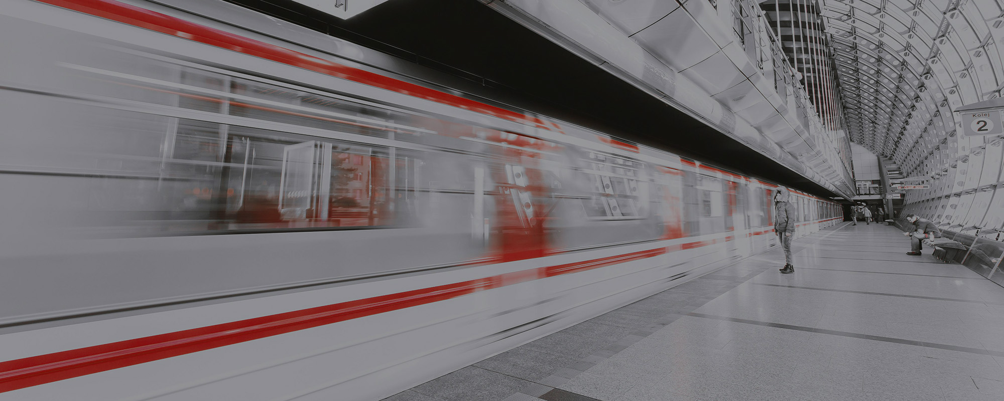 Interior of a subway station that has a fast moving train running through it