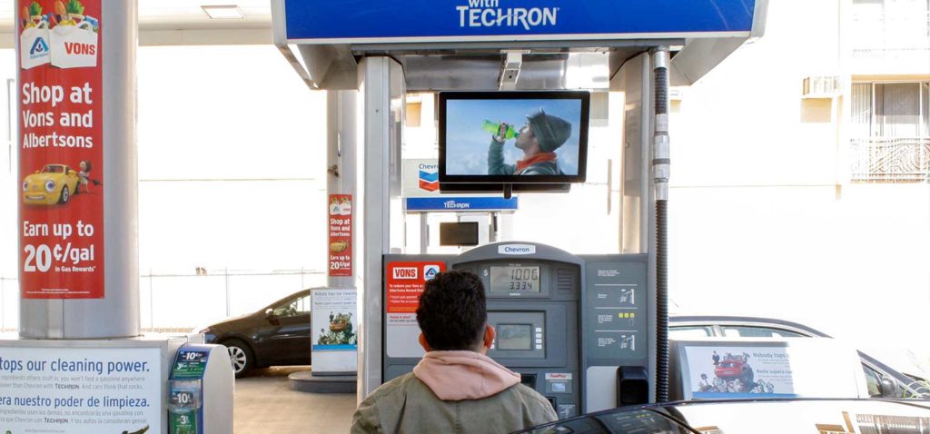 Person watching a Mountain Dew ad while pumping gas into their car