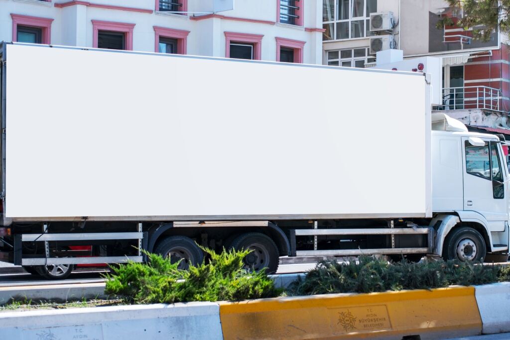 A long ad truck with a white banner