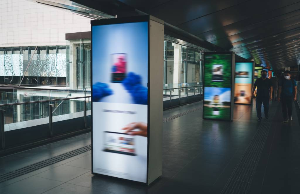 People walking by digital billboards
